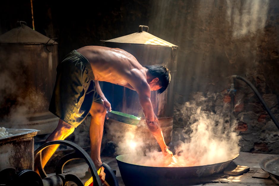 A male artisan working in a steamy, rustic workshop, captured under dramatic lighting.
