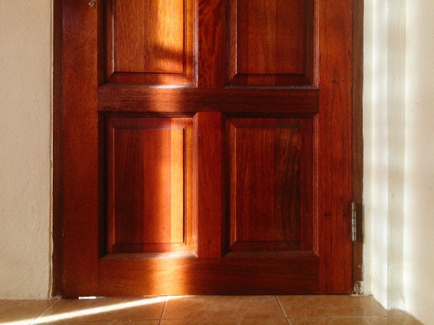 A warm-toned sunlit wooden door showcasing smooth varnish and fine grain details indoors.